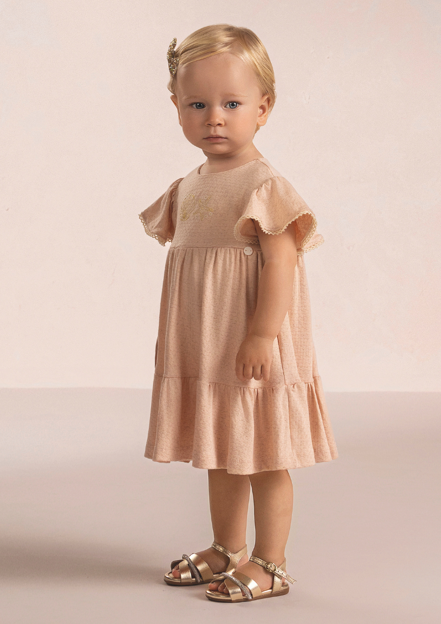 Bebê menina vestindo vestido salmão confortável e delicado para passeios e festas.