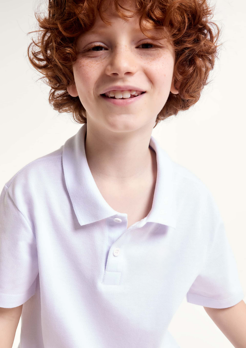 Garoto vestindo camisa polo branca elegante para festas e passeios infantis.