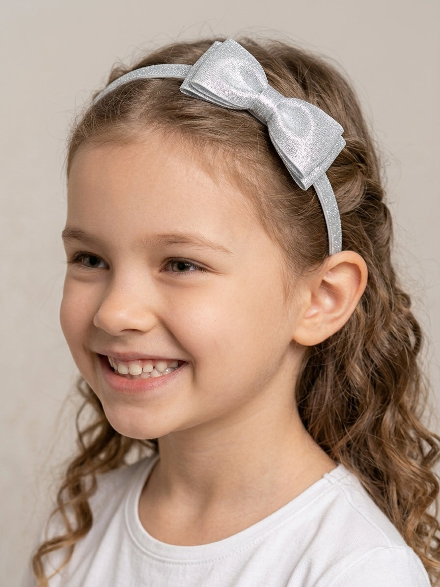 Tiara arquinho infantil com laço brilhoso prata para festas na Lúdica Moda Infantil.