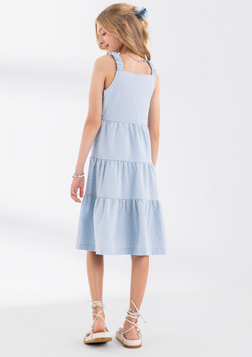 Detalhe do tecido leve e do caimento do vestido juvenil feminino de verão.