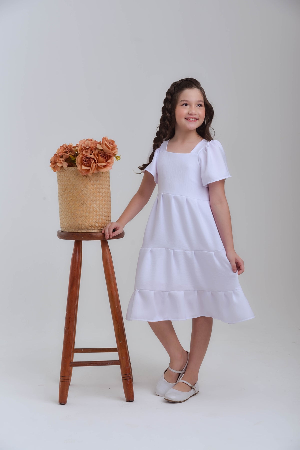 menina sorrindo usando vestido branco elegante para festas 
