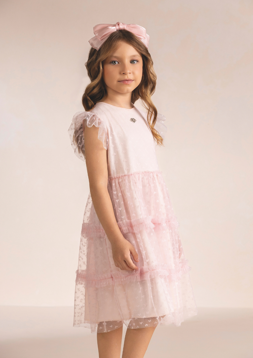 Menina vestindo vestido luxuoso de festa rosa em tule para aniversário e daminha de honra.